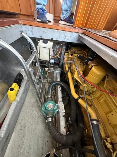 Chapter 2 Yacht Photos Pics Engine compartment of a 1998 Mainship 350 Trawler, showcasing mechanical components and piping.