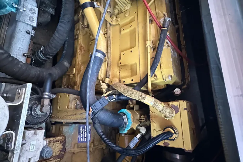 Chapter 2 Yacht Photos Pics Engine compartment of a 1998 Mainship 350 Trawler, showcasing hoses and mechanical components.