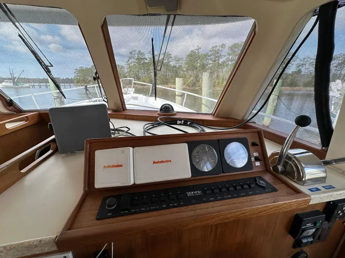 Chapter 2 Yacht Photos Pics 1998 Mainship 350 Trawler helm with navigation instruments and controls, docked by the water.