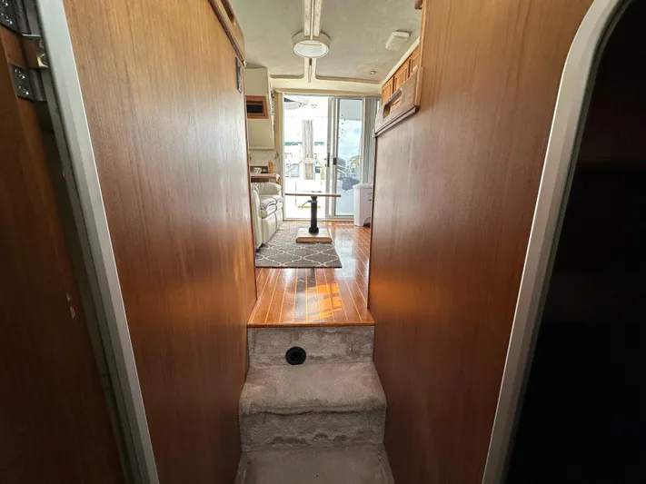 Chapter 2 Yacht Photos Pics Interior view of 1998 Mainship 350 Trawler, featuring wooden paneling and carpeted steps.