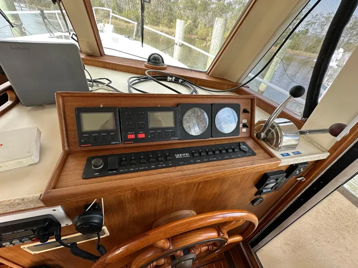 Chapter 2 Yacht Photos Pics 1998 Mainship 350 Trawler helm with navigation instruments and wooden steering wheel.