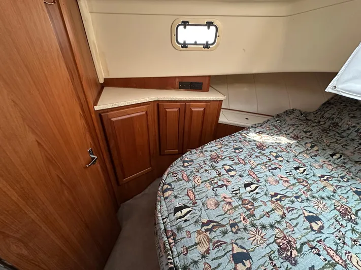 Chapter 2 Yacht Photos Pics 1998 Mainship 350 Trawler cabin with wood cabinetry and patterned bedding.