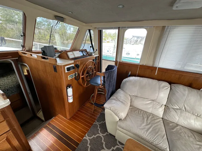 Chapter 2 Yacht Photos Pics Interior of 1998 Mainship 350 Trawler with helm, wooden accents, and beige seating.
