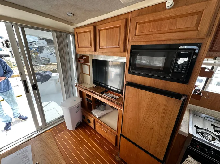 Chapter 2 Yacht Photos Pics Interior of 1998 Mainship 350 Trawler with wood cabinetry, microwave, and sliding glass door.