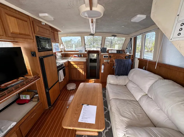 Chapter 2 Yacht Photos Pics Interior of 1998 Mainship 350 Trawler with cozy seating, kitchen, and helm.