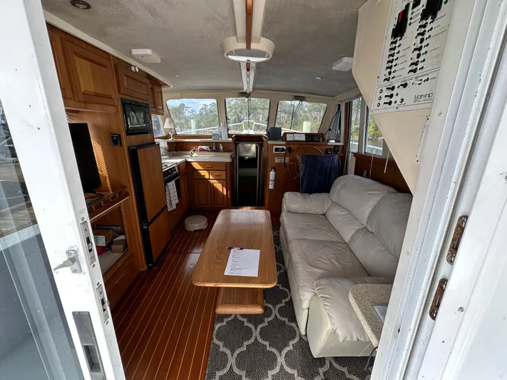 Chapter 2 Yacht Photos Pics 1998 Mainship 350 Trawler interior with sofa, table, and kitchen area.
