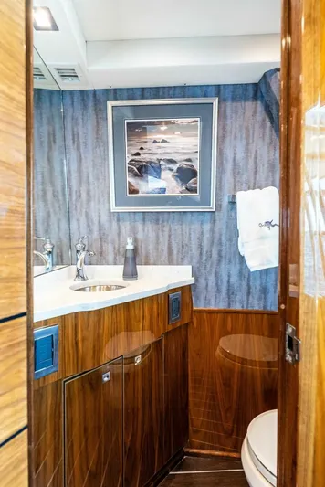 Rachel Anne Yacht Photos Pics Luxurious bathroom in 2022 Viking 80 yacht with elegant wood finishes and modern fixtures.