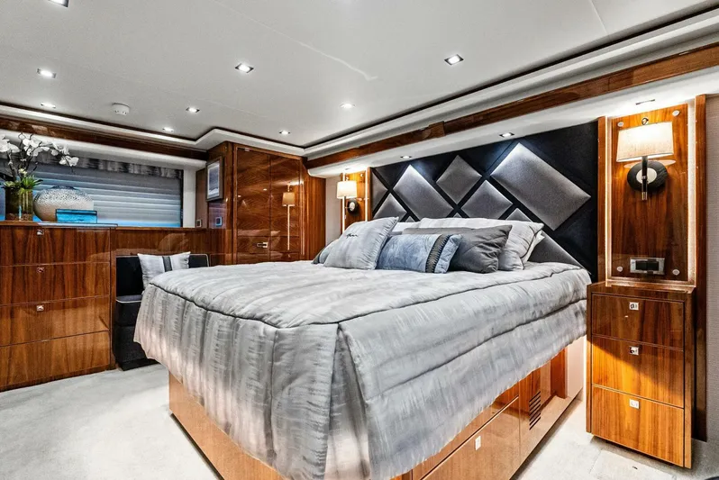Rachel Anne Yacht Photos Pics Luxurious bedroom interior on a 2022 Viking 80 yacht, featuring elegant wood finishes and modern lighting.