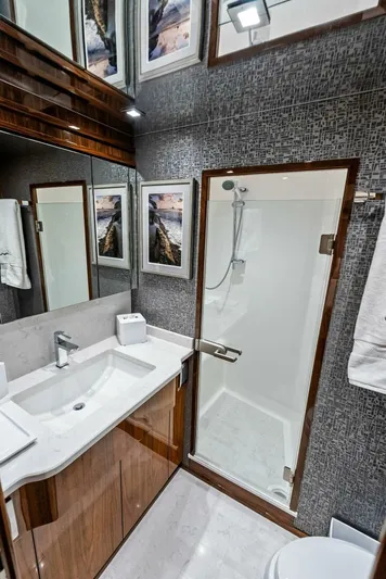 Rachel Anne Yacht Photos Pics Luxurious 2022 Viking 80 yacht bathroom with modern shower and elegant wood finishes.