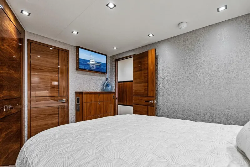 Rachel Anne Yacht Photos Pics Luxurious bedroom interior on a 2022 Viking 80 yacht, featuring elegant wood finishes.