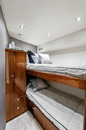Rachel Anne Yacht Photos Pics 2022 Viking 80 yacht interior with modern bunk beds and sleek wooden cabinetry.
