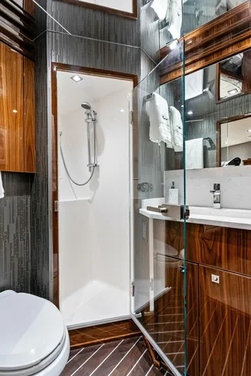 Rachel Anne Yacht Photos Pics Luxurious 2022 Viking 80 yacht bathroom with modern shower and elegant wood finishes.