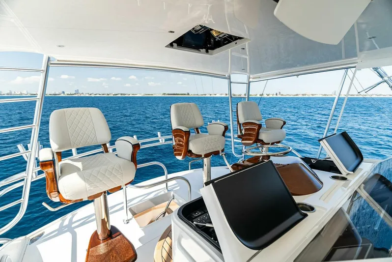 Rachel Anne Yacht Photos Pics Luxurious 2022 Viking 80 yacht helm with plush seating and advanced navigation systems on open sea.