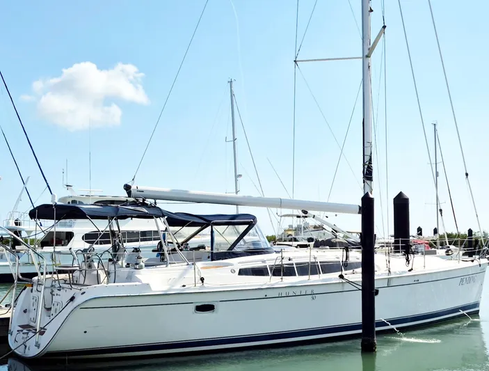 Pending Yacht Photos Pics 2012 Hunter 50 Aft Cockpit sailboat docked in marina under clear blue sky.