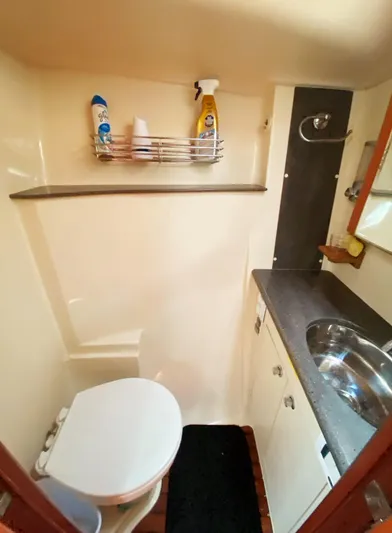 Pending Yacht Photos Pics 2012 Hunter 50 Aft Cockpit bathroom with toilet, sink, and storage shelf.