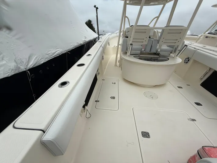  Yacht Photos Pics 2014 Pursuit ST 310 Sport boat deck with seating and storage compartments.