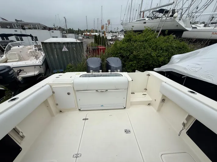  Yacht Photos Pics 2014 Pursuit ST 310 Sport boat deck with dual engines, docked in a marina.