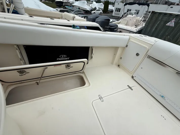 Yacht Photos Pics 2014 Pursuit ST 310 Sport boat interior with storage compartments and seating.