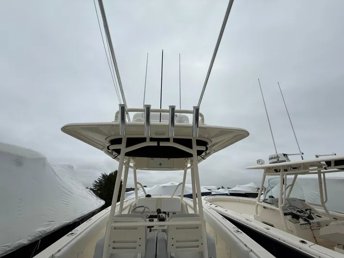  Yacht Photos Pics 2014 Pursuit ST 310 Sport boat with T-top and rod holders, docked under cloudy skies.