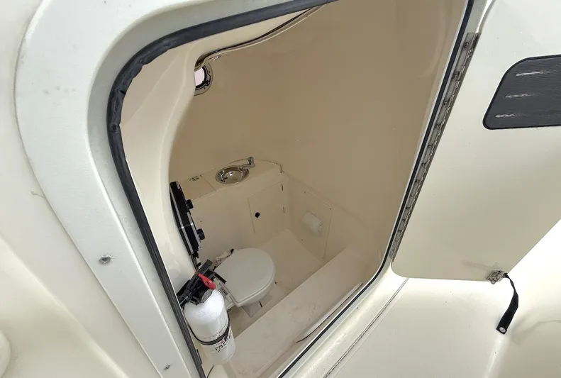  Yacht Photos Pics 2014 Pursuit ST 310 Sport boat interior with compact marine toilet and fire extinguisher.