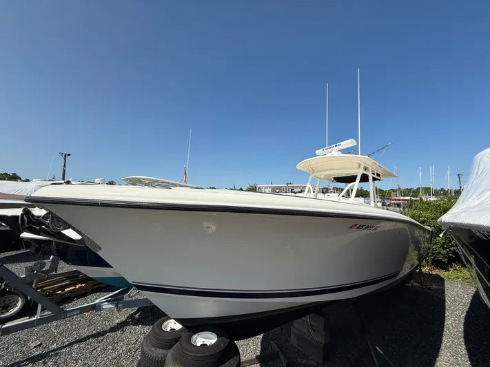  Yacht Photos Pics 2014 Pursuit ST 310 Sport boat on display in a marina under clear blue sky.