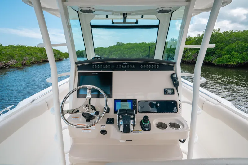 Yacht Photos Pics 2019 Boston Whaler 330 Outrage helm with modern controls and scenic waterway view.