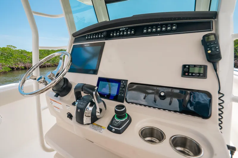  Yacht Photos Pics 2019 Boston Whaler 330 Outrage helm with steering wheel, controls, and navigation screens.