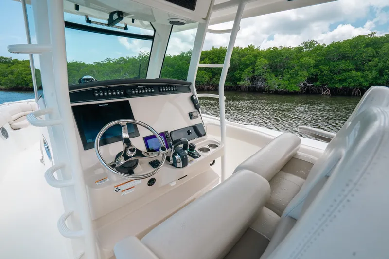  Yacht Photos Pics 2019 Boston Whaler 330 Outrage boat interior with steering wheel and control panel.
