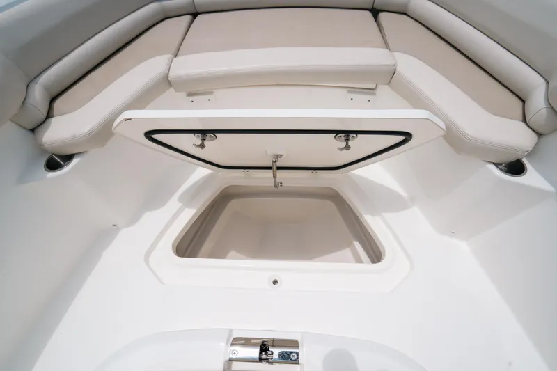  Yacht Photos Pics 2019 Boston Whaler 330 Outrage boat with open storage compartment and cushioned seating.