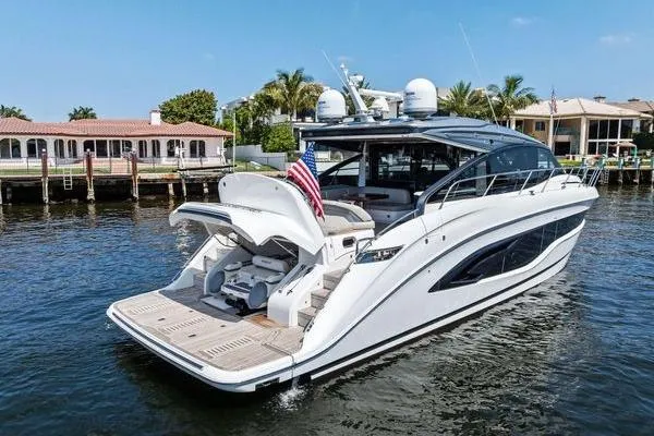 Endless Summer Yacht Photos Pics Luxury 2020 Princess V55 yacht docked on serene waterfront with American flag.