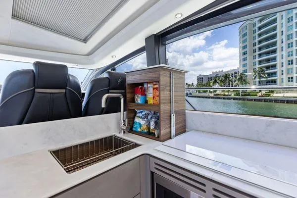 Endless Summer Yacht Photos Pics Luxurious 2020 Princess V55 yacht interior with modern kitchen and scenic waterfront view.