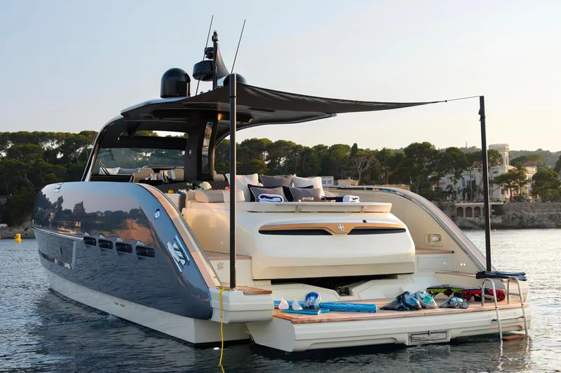  Yacht Photos Pics 2023 Invictus TT460 yacht anchored, featuring luxurious deck and scenic coastal backdrop.