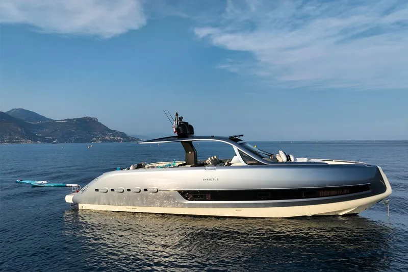  Yacht Photos Pics 2023 Invictus TT460 yacht on serene water with scenic mountain backdrop.