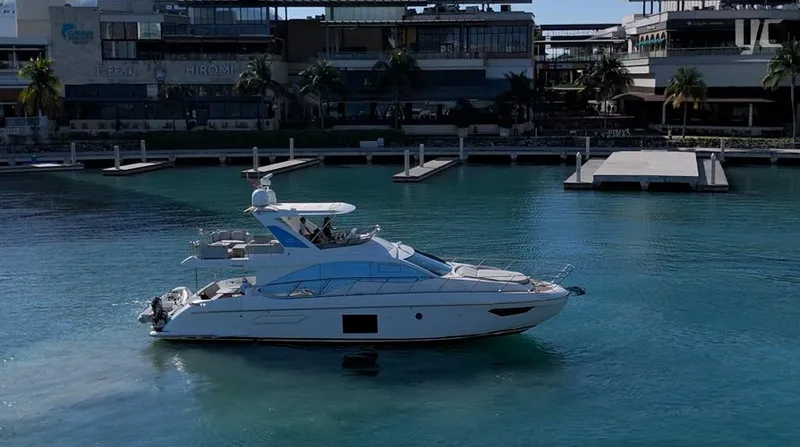 Resilience Yacht Photos Pics 2021 Azimut 55 yacht docked in a marina with modern buildings in the background.