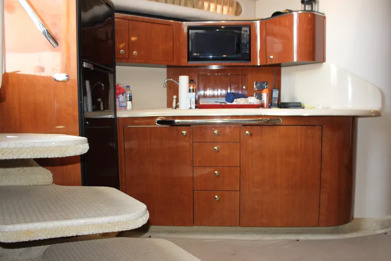  Yacht Photos Pics Interior of 2003 Sea Ray 380 Sundancer yacht kitchen with wooden cabinets and appliances.