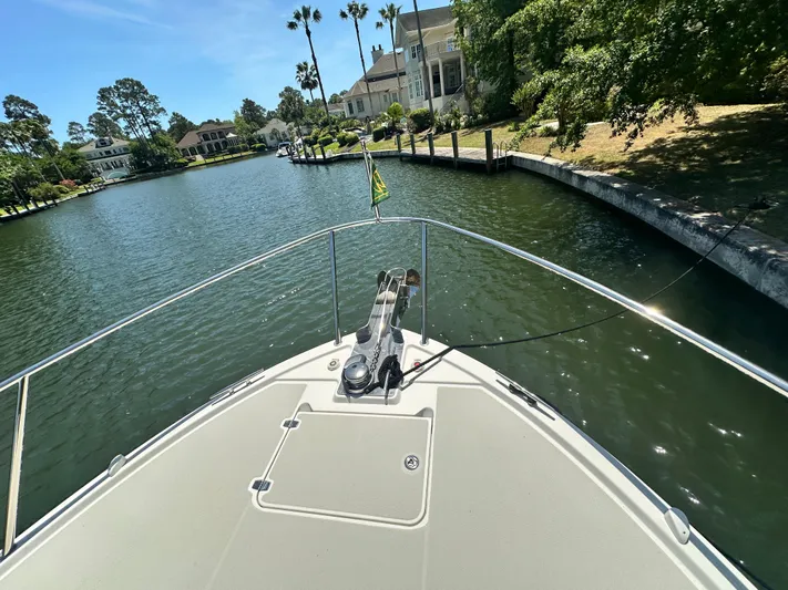  Yacht Photos Pics Bow view of 2022 Back Cove 372 yacht navigating a scenic residential waterway.