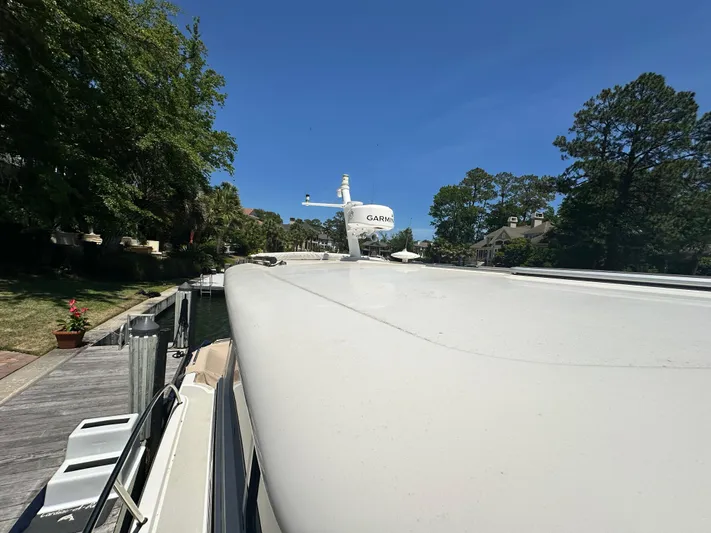 Yacht Photos Pics 2022 Back Cove 372 boat docked, surrounded by trees and clear blue sky.