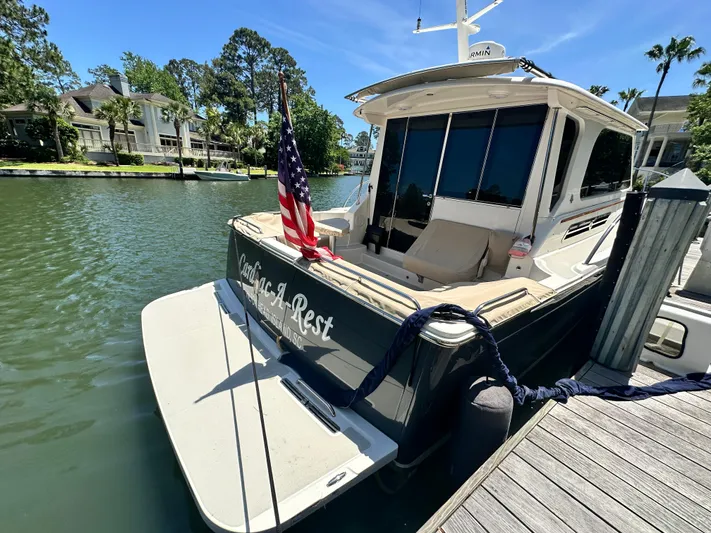  Yacht Photos Pics 2022 Back Cove 372 yacht docked, displaying American flag, surrounded by waterfront homes.