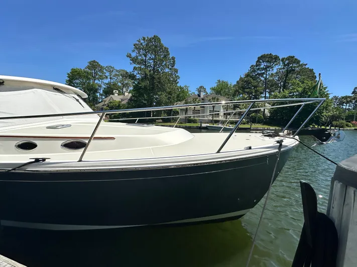  Yacht Photos Pics 2022 Back Cove 372 boat docked on a sunny day, surrounded by trees and houses.