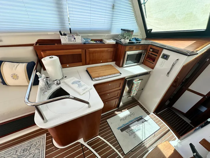  Yacht Photos Pics 2022 Back Cove 372 yacht interior kitchen with wooden cabinetry and modern appliances.