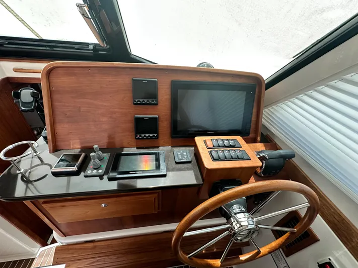  Yacht Photos Pics 2022 Back Cove 372 helm with wooden wheel, modern controls, and navigation screens.