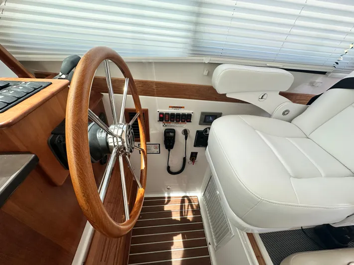  Yacht Photos Pics 2022 Back Cove 372 helm with wooden steering wheel and white captain's chair.