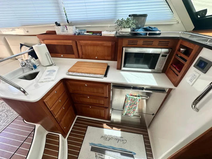  Yacht Photos Pics Modern kitchen in 2022 Back Cove 372 yacht with wooden cabinetry and stainless steel appliances.
