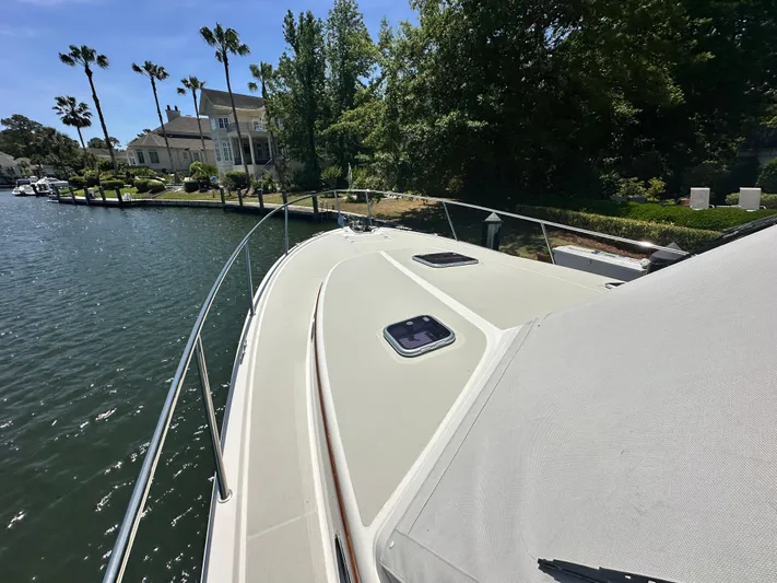  Yacht Photos Pics 2022 Back Cove 372 boat docked by waterfront homes and palm trees.