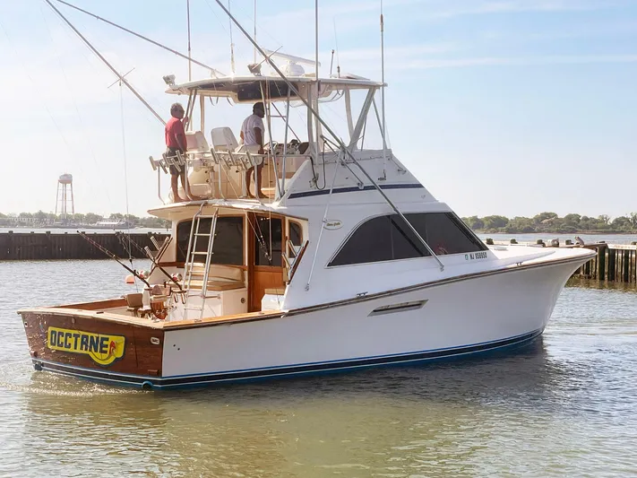 Occtane Yacht Photos Pics 1990 Ocean Yachts 44 Super Sport boat on water, featuring fishing rods and two people onboard.