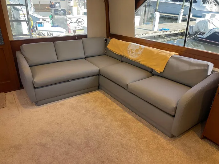 Occtane Yacht Photos Pics Gray sectional sofa in 1990 Ocean Yachts 44 Super Sport interior, with dock view.