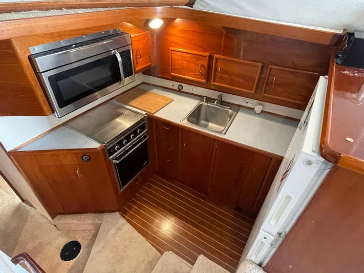 Occtane Yacht Photos Pics 1990 Ocean Yachts 44 Super Sport galley with wood cabinetry, microwave, stove, and sink.