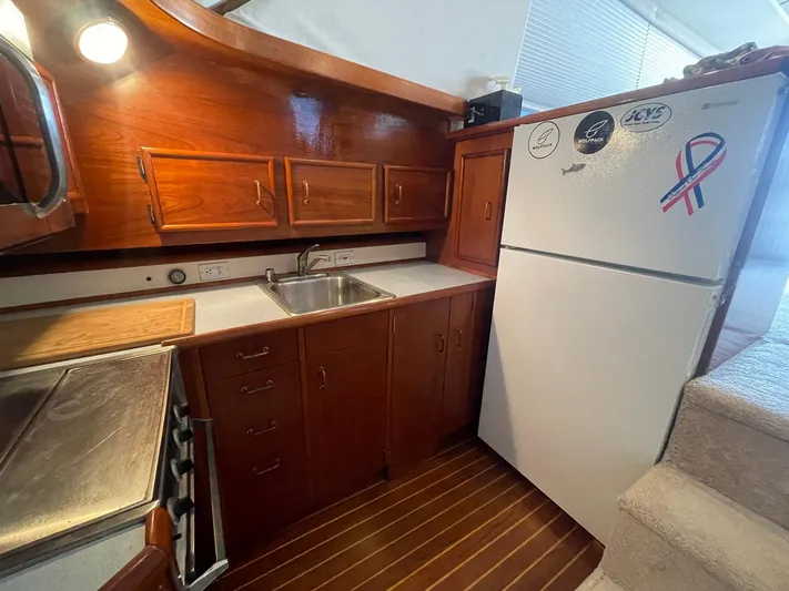 Occtane Yacht Photos Pics 1990 Ocean Yachts 44 Super Sport kitchen with wooden cabinets and stainless steel sink.