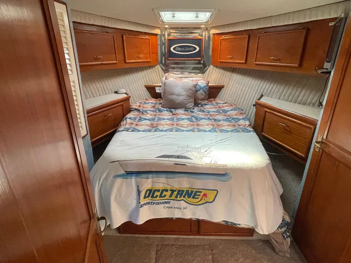 Occtane Yacht Photos Pics 1990 Ocean Yachts 44 Super Sport cabin with bed, wooden cabinets, and nautical decor.
