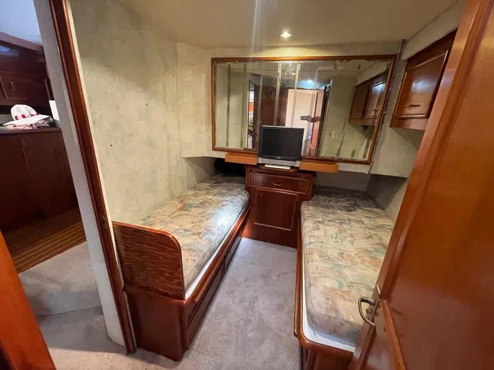 Occtane Yacht Photos Pics 1990 Ocean Yachts 44 Super Sport cabin with twin beds, TV, and wooden cabinetry.